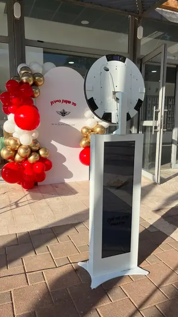 עמדת צילום לבנה ובלונים אדומים וזהב