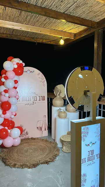 עמדת צילום ליד קיר בלונים אדום-לבן